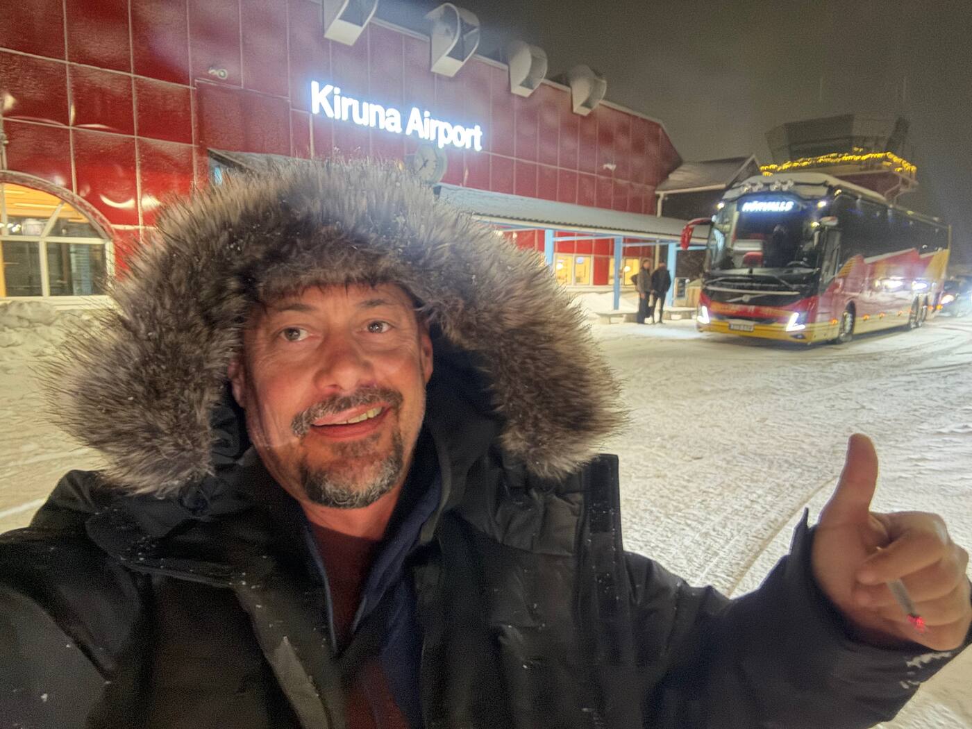 Arrivée de nuit à Kiruna Airport, capuche fourrée, bus sous la neige